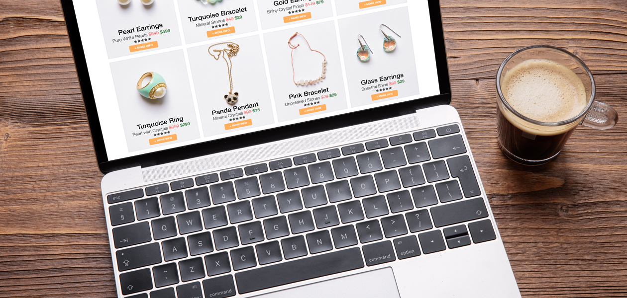 All-in-one: Berufshaftpflicht für etsy Händler Ein Laptop steht auf dem Tisch. Auf dem Bildschirm sieht man verschiedene Schmuckstücke zum Kauf. Neben dem Tisch steht eine Tasse Kaffee.